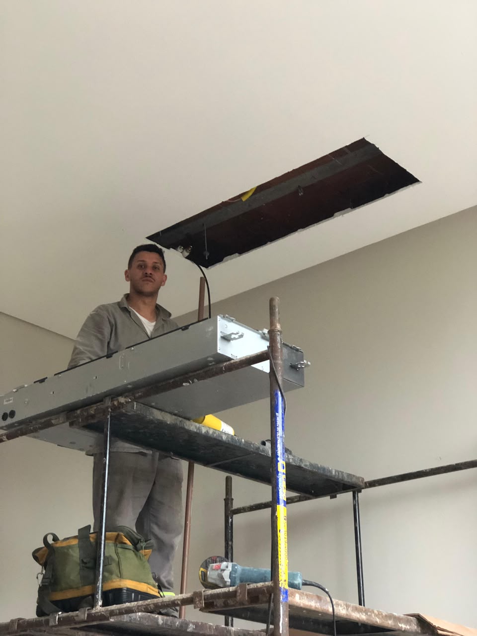 Técnico da Lerin instalando equipamento de climatização no teto